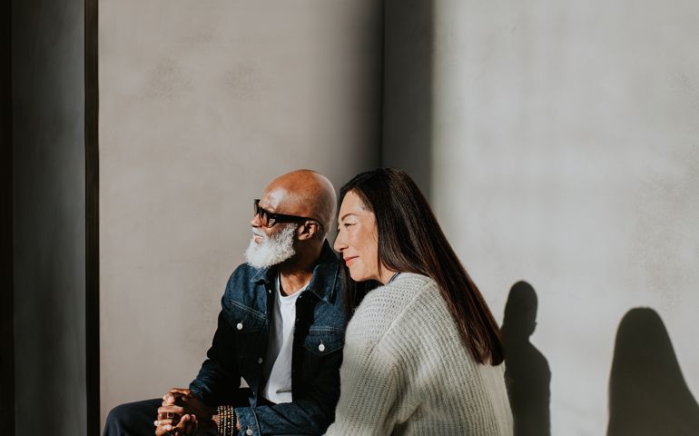 Conceptual, simple image of a man and a woman sitting beside each other.