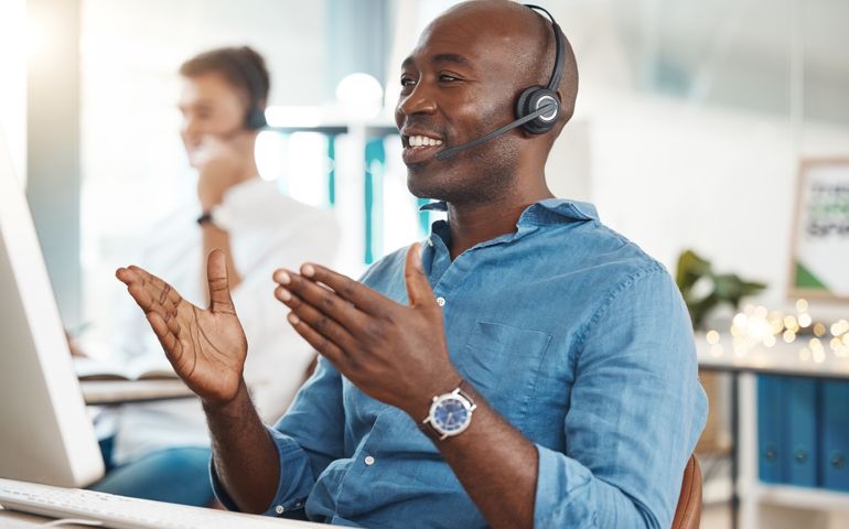 Call center, telemarketing and customer service with a business man working in an office and consulting on a headset. Help, crm and contact us with a black male consult at work on a computer