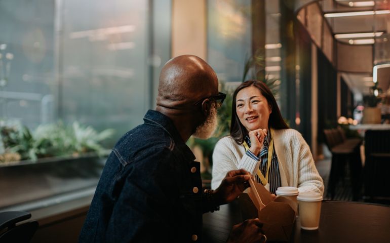Cinematic image of a man and a woman sitting at a table in a cafe