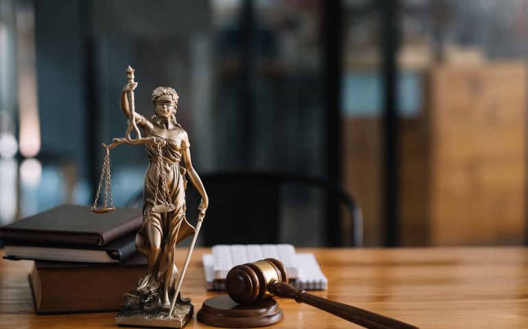 Statue of lady justice on desk of a judge or lawyer.