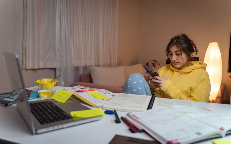 Girl is Working on Homework for School. Young Female Reading Research Articles About Her Hobby. Education Concept