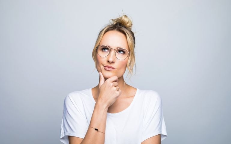 Thoughtful woman with hand on chin looking up