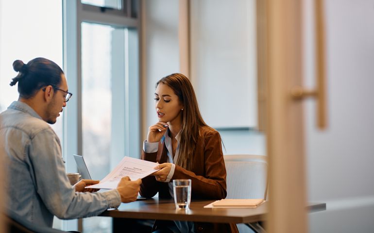 Human resource manager going through documents with male candidate in the office.