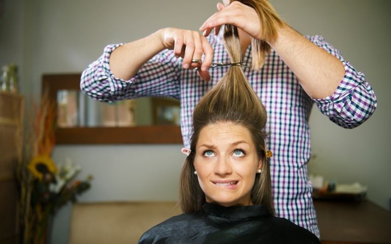 Nervous brunette woman getting haircut at a salon