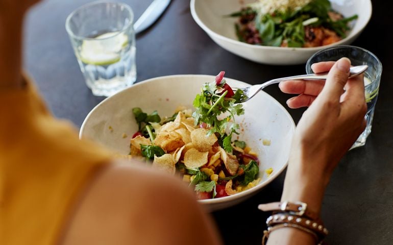 Woman having food at restaurant table