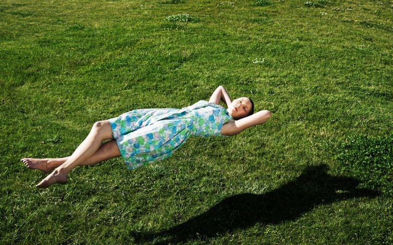 Woman realxing floating above the grass