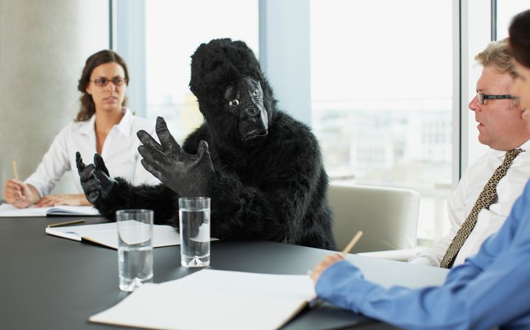 Gorilla and businesspeople having meeting in conference room