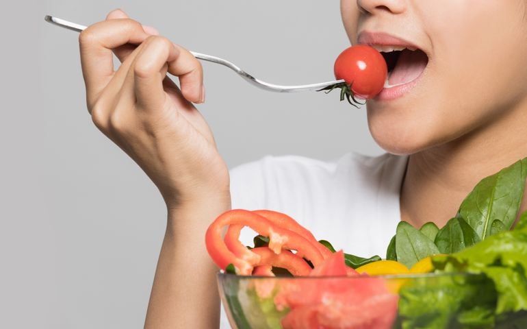 Young woman eating a salad.