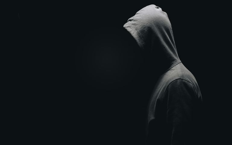 side view of unrecognizable man in man standing isolated on black