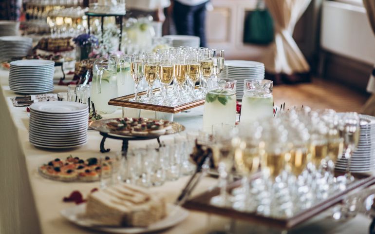 stylish champagne glasses and food appetizers on table at wedding reception. luxury catering at celebrations. serving food and drinks at events concept