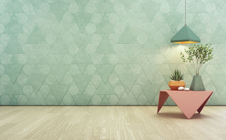 Indoor plant on pink steel coffee table and lamp with empty turquoise triangle pattern wall background, Relaxing area in pastel room of modern house.