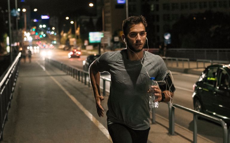Young man jogging through the city at night