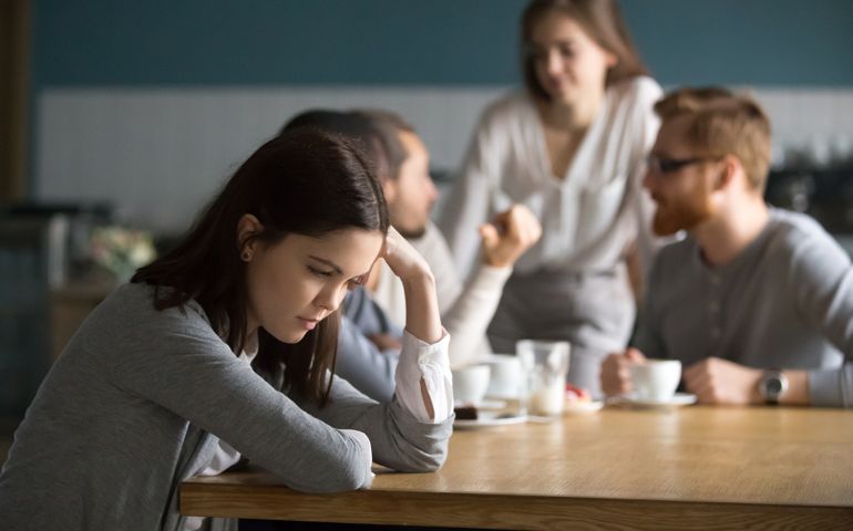Sad young girl feeling lonely sit alone in coffee shop