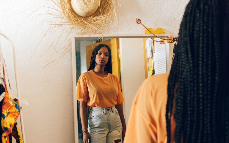Young woman looking in the mirror