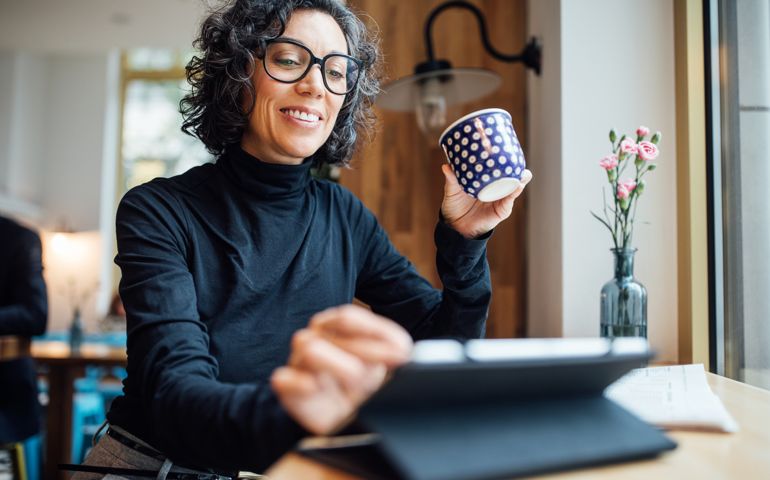 Woman at cafe using digital tablet at coffee shop
