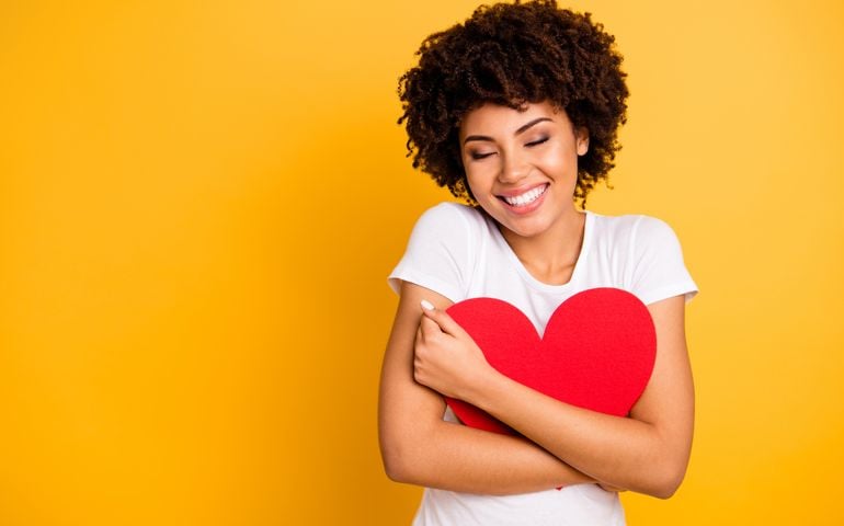 Close up photo beautiful amazing she her dark skin lady adorable remember cuddle big paper card heart shape figure form dreamy wear casual white t-shirt isolated yellow bright vibrant background