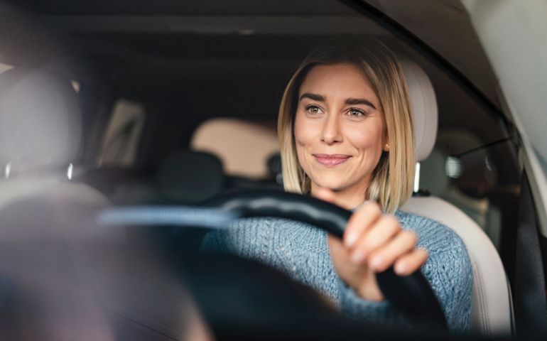 Portrait of smiling young woman driving a car