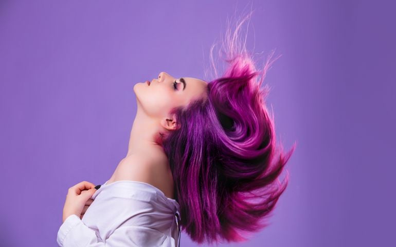 Model girl young beautiful stylish with hair dyed purple on violet background