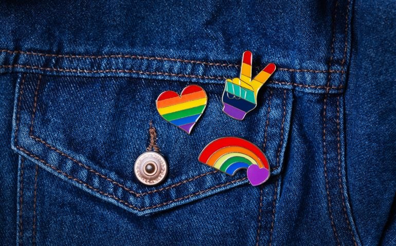 Rainbow lgbtq flag badges against denim background, pride month