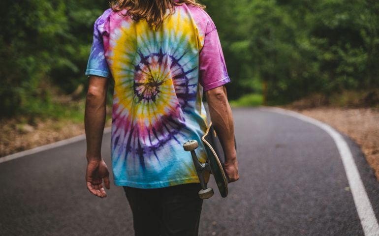 Cropped photo of a man wearing a tie-dye T-shirt.
