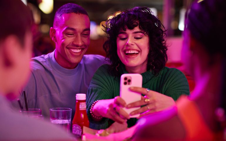 Cheerful woman taking selfie with man