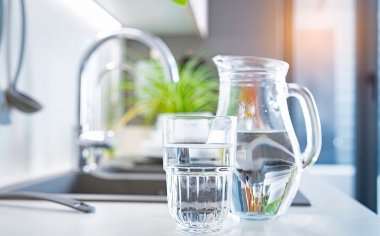 Glass of water and jug on kitchen counter
