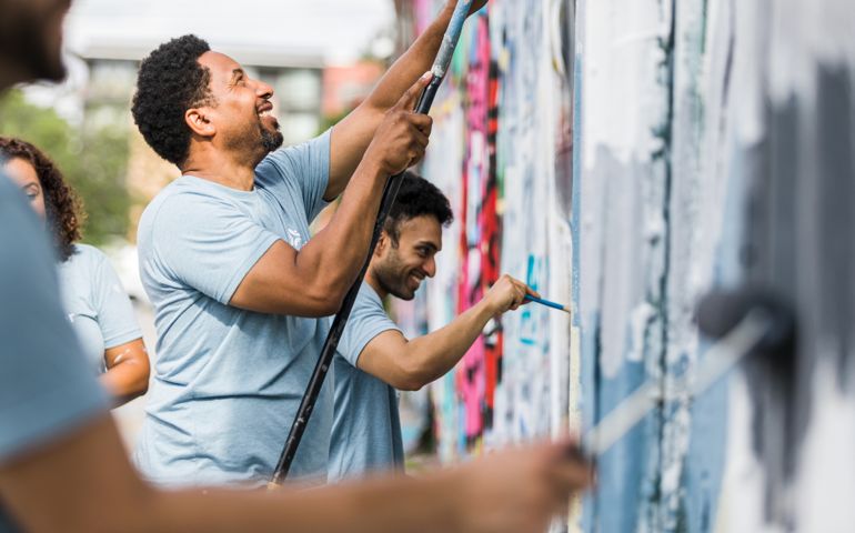 Coworkers smiling while they paint