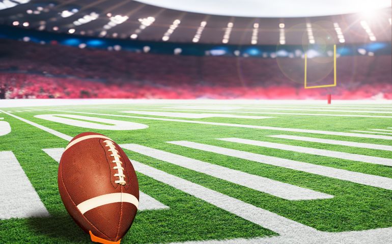 American football field goal post with ball on kicking tee