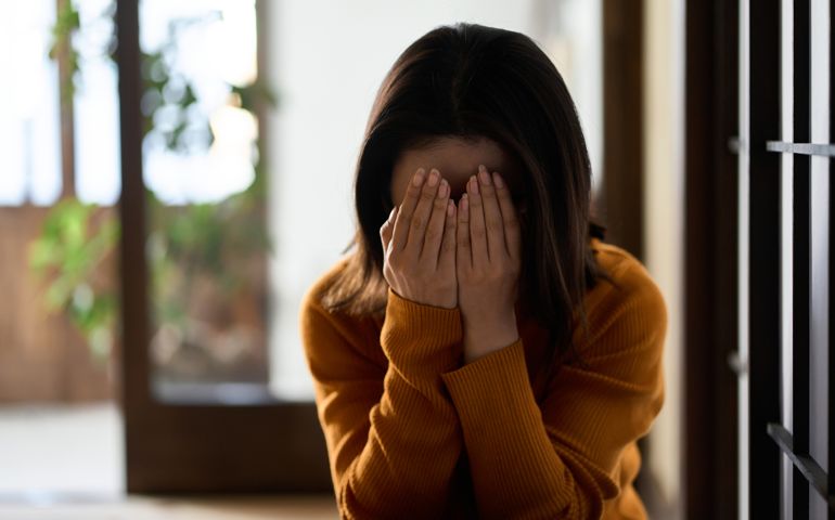 woman covering her face with both hands