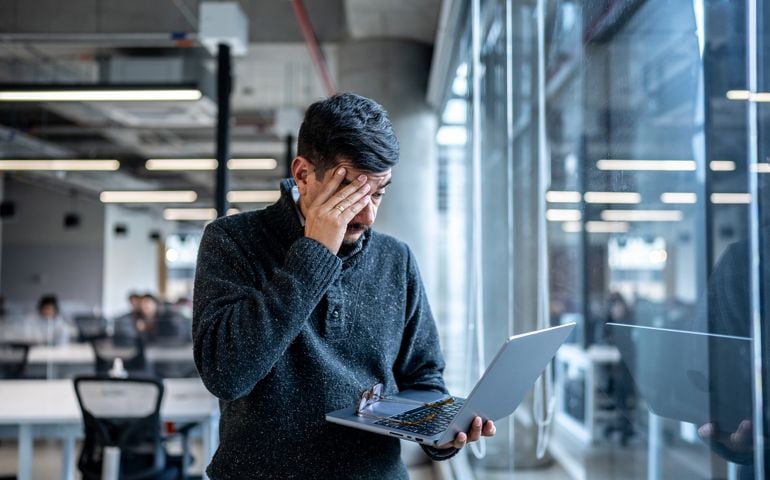 Worried mature man using laptop working at office