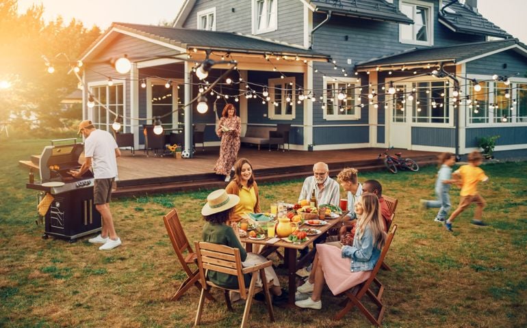 Big Family and Friends Celebrating Outside at Home. Diverse Group of Children, Adults and Old People Gathered at a Table, Having Fun Conversations. Preparing Barbecue and Eating Vegetables.