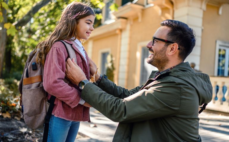 Father taking his daughter to school