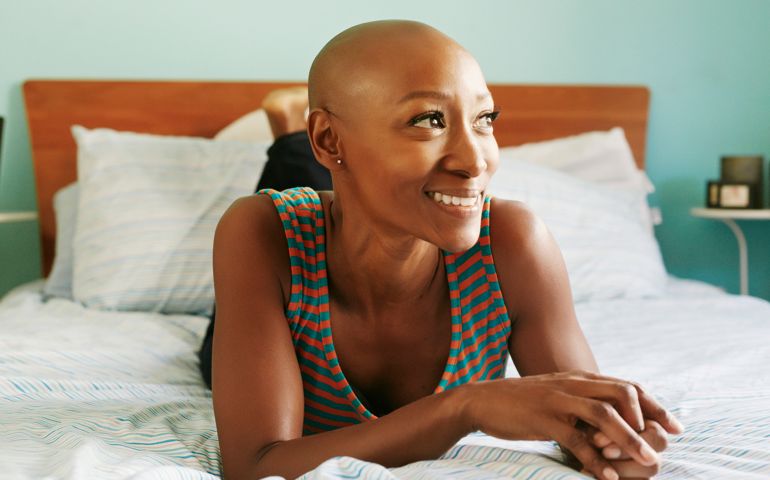 Smiling African American woman laying on bed