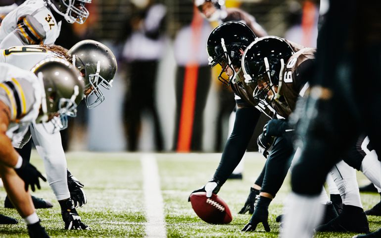 Football teams on line of scrimmage in stadium