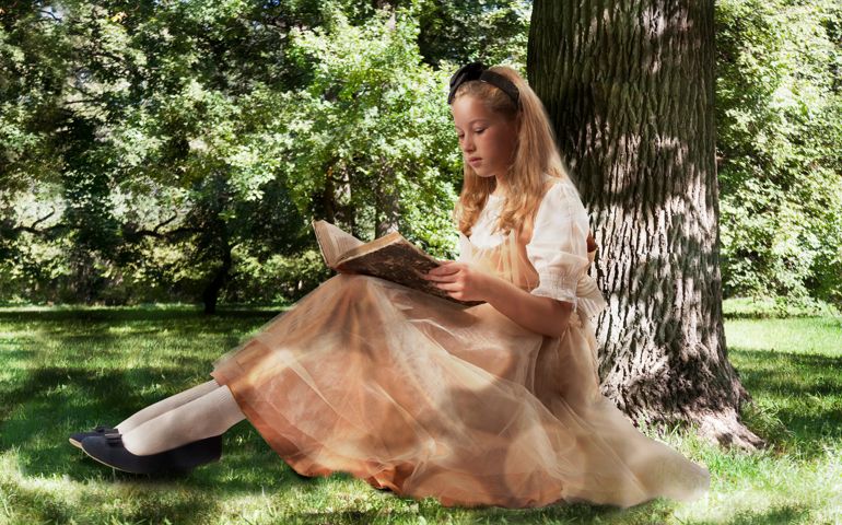 Little girl reading ancient book