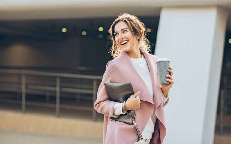 Elegant woman walking outdoors and looking back