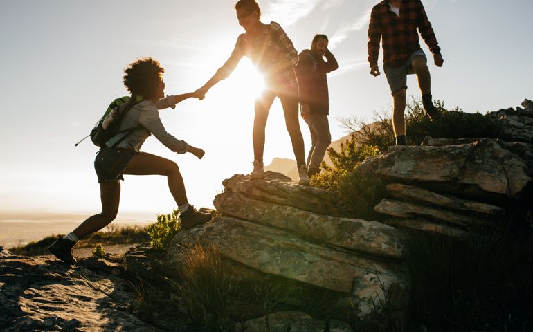 Young people on mountain hike at sunset