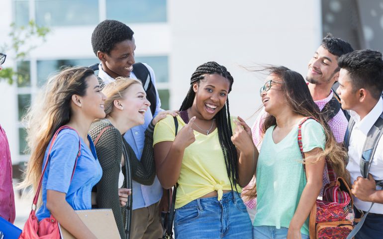 Teenage girl with multi-ethnic friends outside school