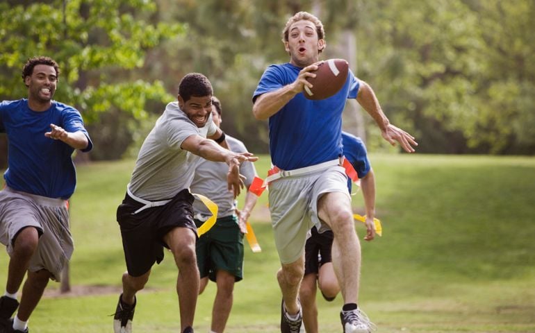 Men playing flag football together