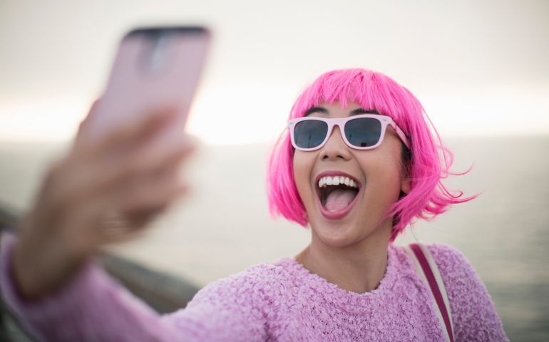Young woman with pink hair taking a selfie