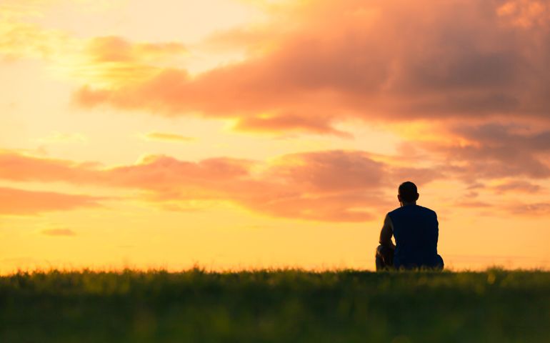 Man sitting watching sunset