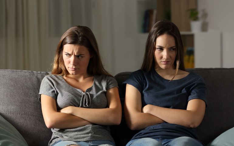 Angry friends ignoring each other at home in the night