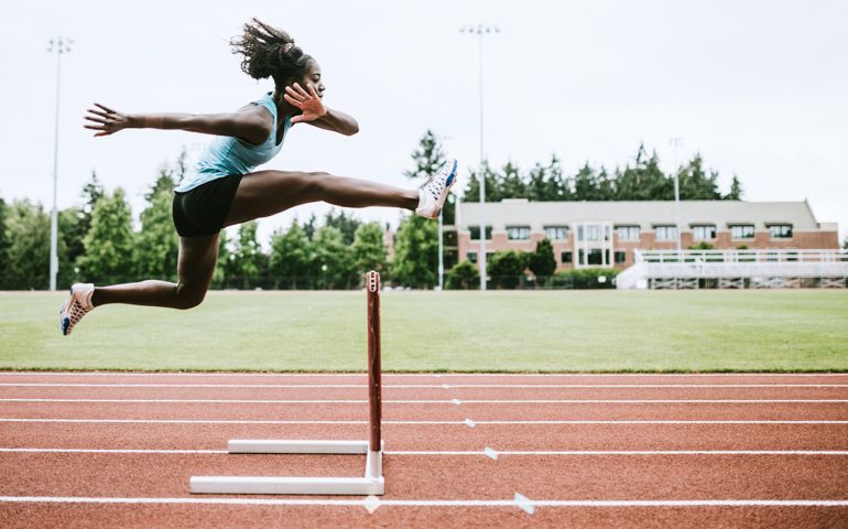 Woman Athlete Runs Hurdles for Track and Field