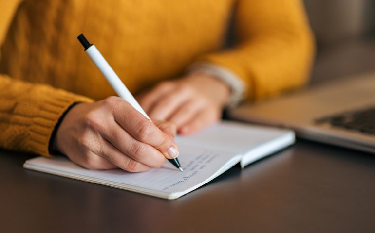 Writing in notebook. Close-up.
