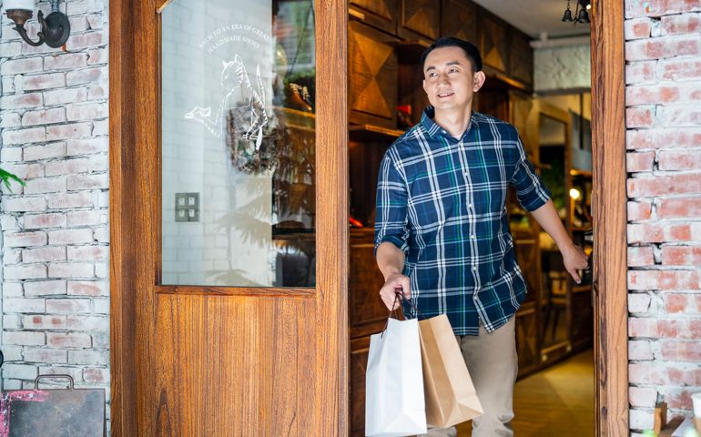 Customer with shopping bags leaving from store