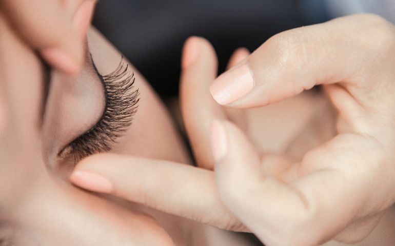 Makeup artist applying false eyelash
