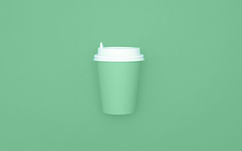Reusable eco friendly bamboo cup for take away coffee on mint background. Space for text. Flat lay, top view. Bring your own cup concept. Zero waste, sustainable lifestyle. Mock up.
