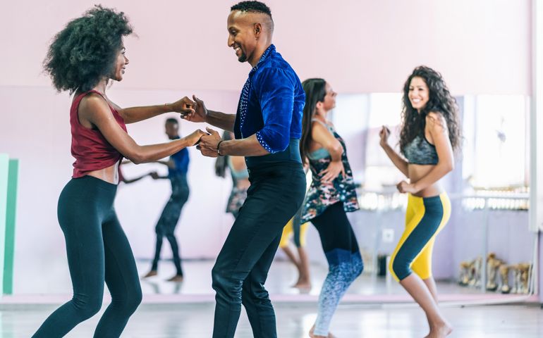Couple dancers practicing in studio, holding hands
