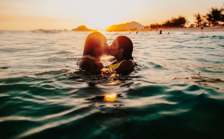 View of two woman swimming and kissing