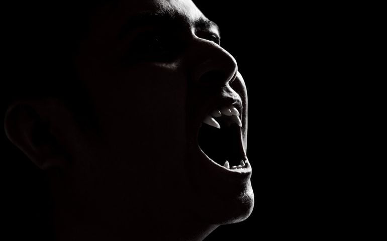 Scary vampire man on dark background